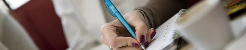 Hand maakt aantekeningen in een notitieboek tijdens een gesprek