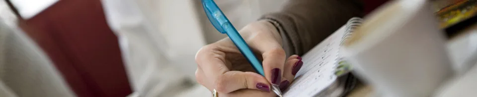 Hand maakt aantekeningen in een notitieboek tijdens een gesprek