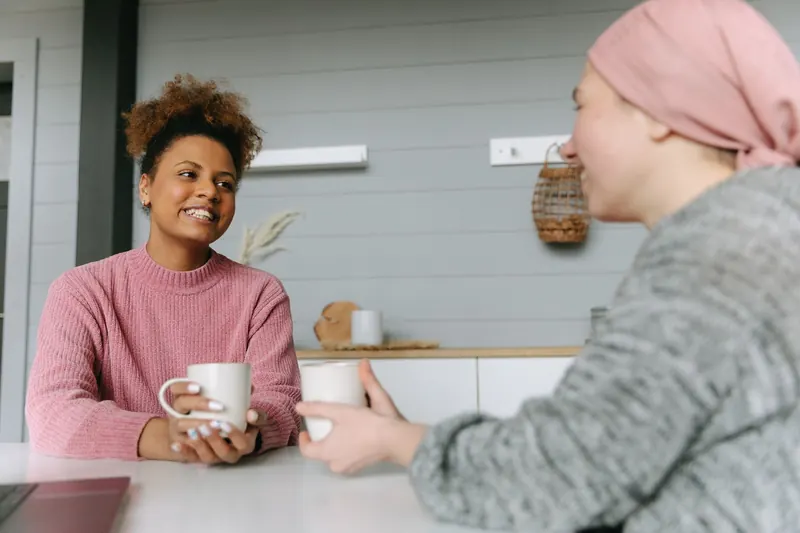 Twee vrouwen in gesprek met een kop koffie