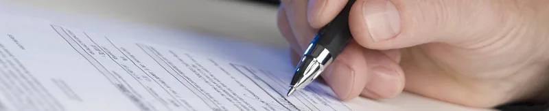Hand met pen vult een formulier in