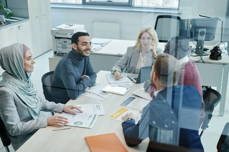 Professionals in overleg rond een tafel in een modern kantoor