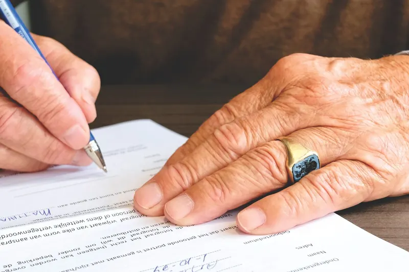Oudere persoon ondertekent een document